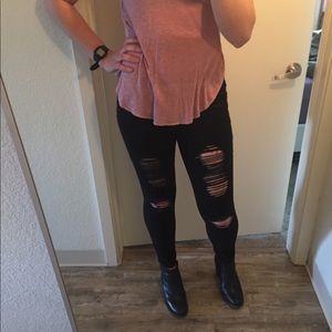 Black jeans with rips along front thigh
